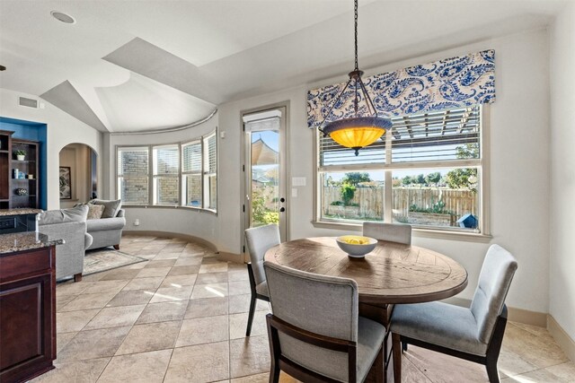 tiled dining area with plenty of natural light and lofted ceiling