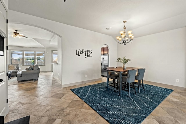 dining room with vaulted ceiling and ceiling fan with notable chandelier