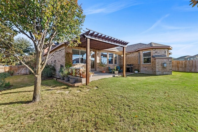 back of property with a pergola, a patio, and a lawn