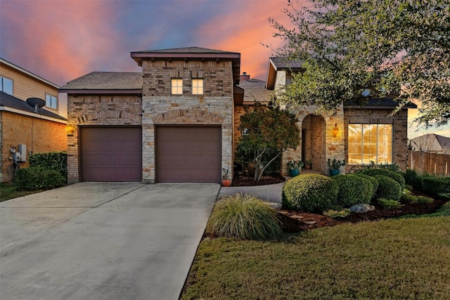 view of front facade featuring a garage, stone siding, and driveway