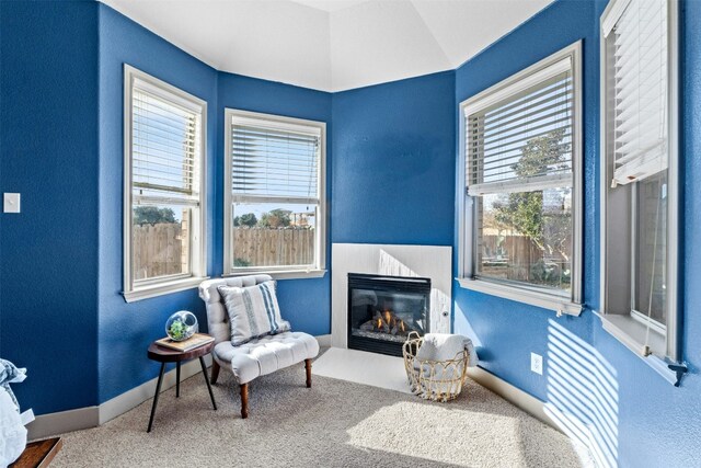 sitting room featuring carpet flooring, a healthy amount of sunlight, and vaulted ceiling