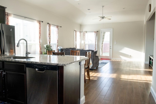 kitchen featuring stainless steel dishwasher, ceiling fan, sink, hardwood / wood-style floors, and an island with sink