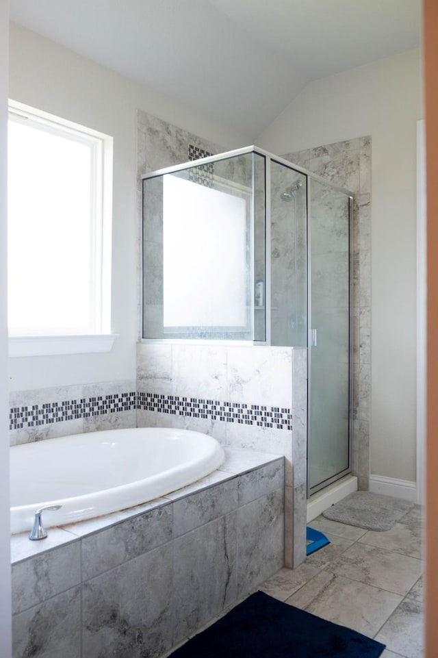 bathroom featuring independent shower and bath and lofted ceiling