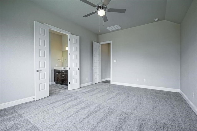 unfurnished bedroom with light colored carpet, ceiling fan, lofted ceiling, and ensuite bathroom