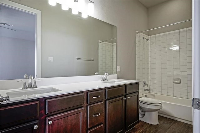 full bathroom featuring wood-type flooring, vanity, toilet, and tiled shower / bath