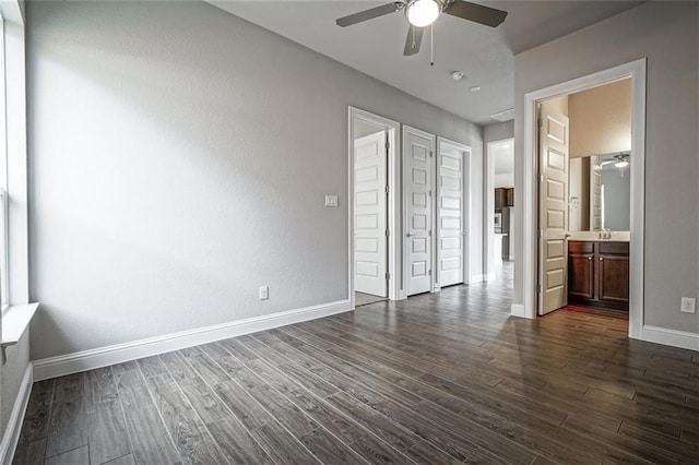 unfurnished bedroom featuring a closet, ensuite bath, ceiling fan, and dark hardwood / wood-style flooring