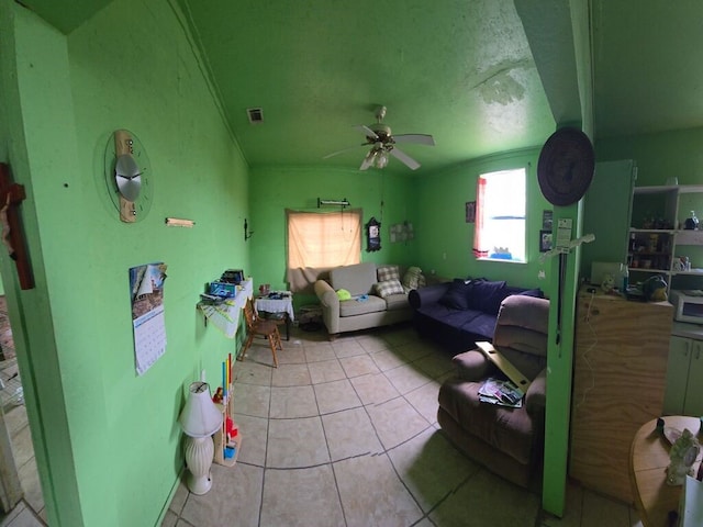 living room featuring ceiling fan, a textured ceiling, and light tile patterned floors