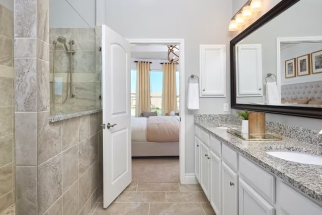 bathroom featuring tiled shower and vanity