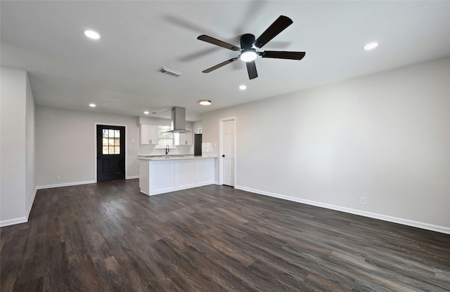 unfurnished living room with dark hardwood / wood-style flooring, ceiling fan, and sink