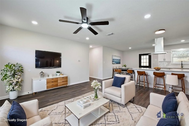 living room with ceiling fan, sink, and hardwood / wood-style flooring