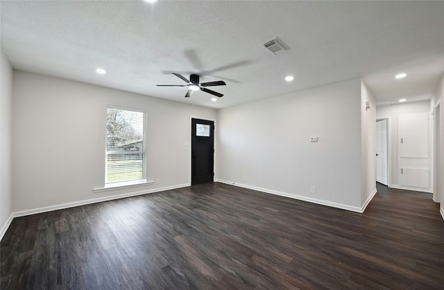 spare room featuring a textured ceiling, ceiling fan, and dark wood-type flooring