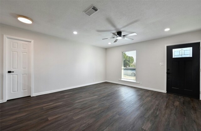 entrance foyer with ceiling fan, dark wood-type flooring, and a textured ceiling