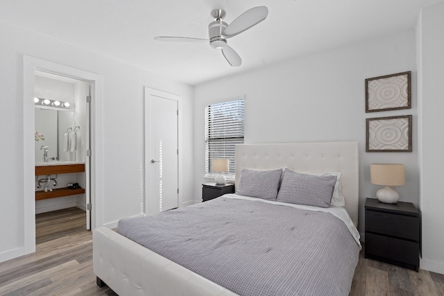 bedroom with hardwood / wood-style floors, ensuite bathroom, and ceiling fan