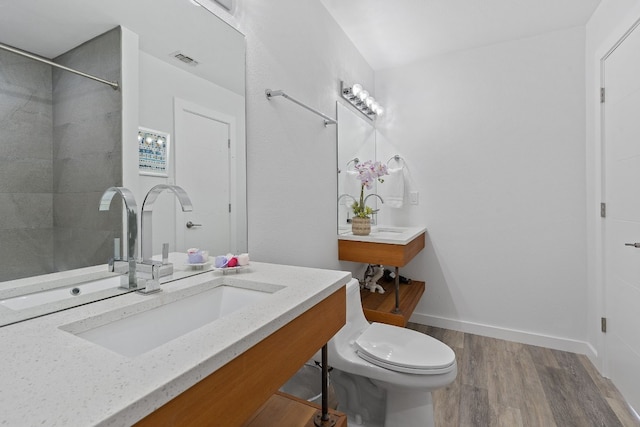 bathroom with vanity, hardwood / wood-style flooring, toilet, and walk in shower