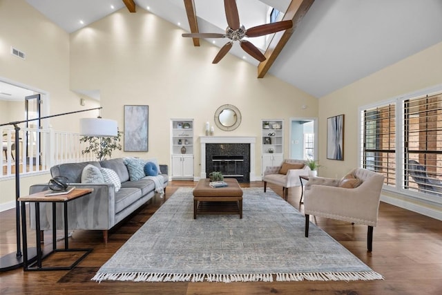 living room with high vaulted ceiling, ceiling fan, dark hardwood / wood-style floors, built in features, and beam ceiling