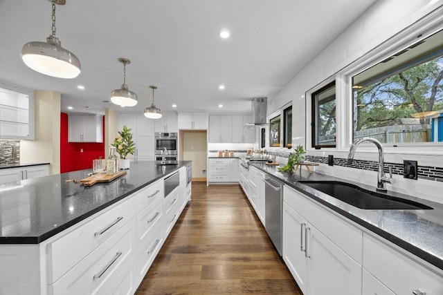 kitchen featuring dark hardwood / wood-style flooring, stainless steel appliances, sink, pendant lighting, and white cabinetry