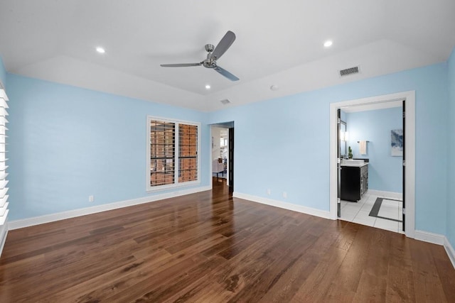 empty room featuring a raised ceiling, ceiling fan, and light wood-type flooring