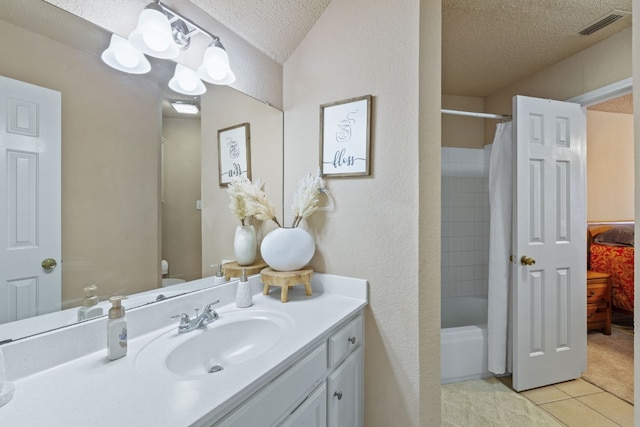 full bathroom featuring vanity, tile patterned floors, toilet, a textured ceiling, and shower / tub combo with curtain