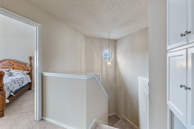 stairs featuring carpet and a textured ceiling