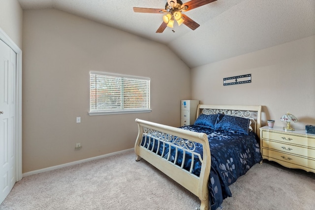 carpeted bedroom with a textured ceiling, ceiling fan, and vaulted ceiling