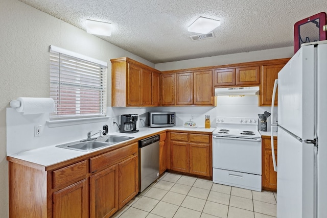 kitchen with light tile patterned floors, a textured ceiling, stainless steel appliances, and sink