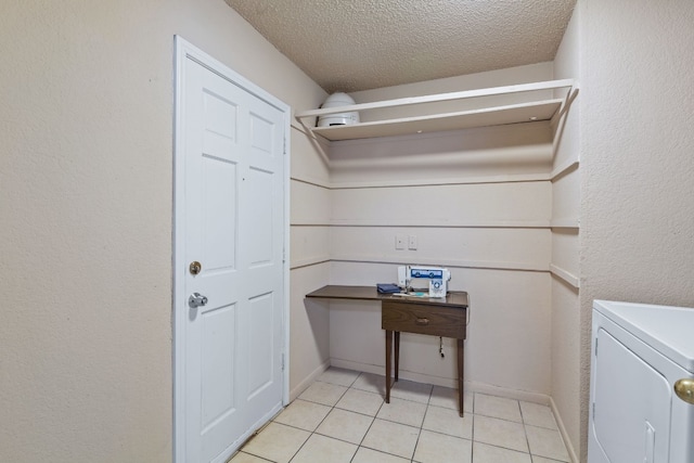 laundry area with washer / dryer, a textured ceiling, and light tile patterned flooring