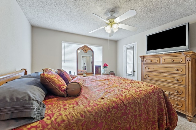 bedroom with ceiling fan, carpet floors, and a textured ceiling