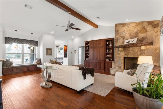 living room featuring beam ceiling, a stone fireplace, ceiling fan, and dark hardwood / wood-style flooring