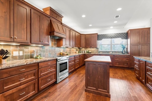 kitchen featuring light stone countertops, a kitchen island, stainless steel electric range, and custom exhaust hood