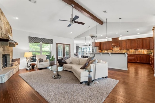 living room featuring ceiling fan, lofted ceiling with beams, a fireplace, and dark wood-type flooring