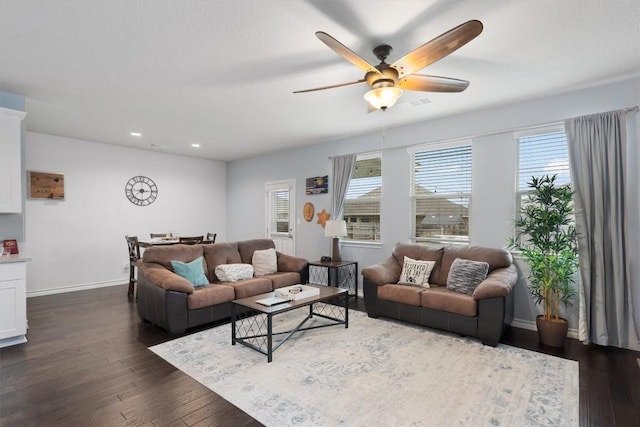 living room featuring ceiling fan and dark hardwood / wood-style floors