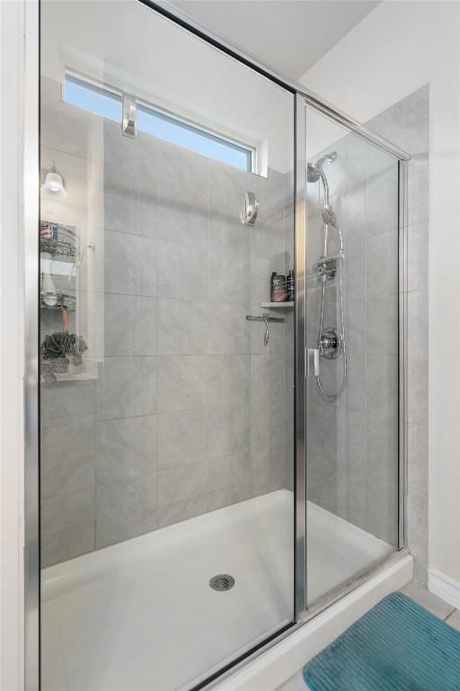 bathroom with tile patterned floors and a shower with door