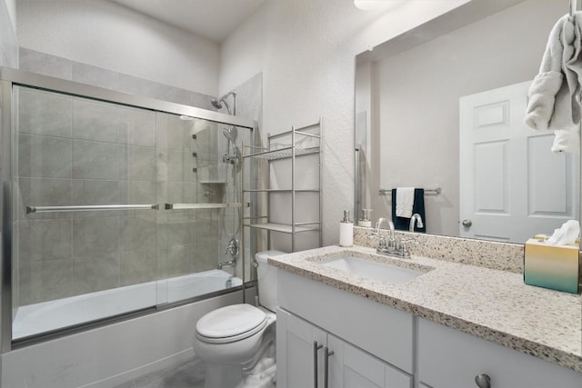 full bathroom with vanity, toilet, and bath / shower combo with glass door