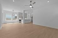 133 Gouda Dr, Bastrop, TX 78602 - unfurnished living room featuring a ceiling fan, baseboards, and wood finished floors