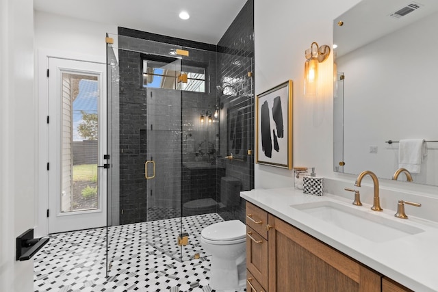 bathroom featuring an enclosed shower, vanity, toilet, and a wealth of natural light