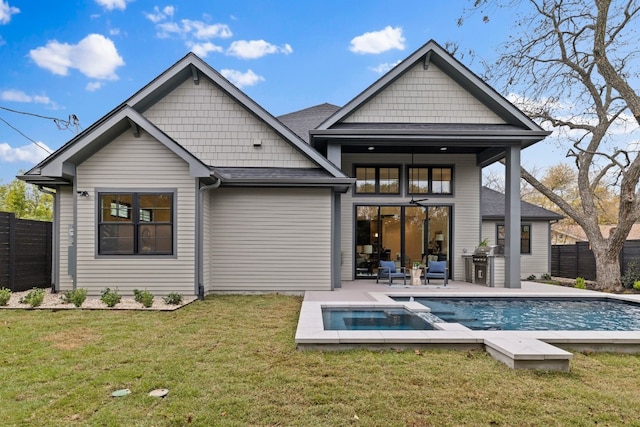 back of property with a fenced in pool, area for grilling, and a lawn