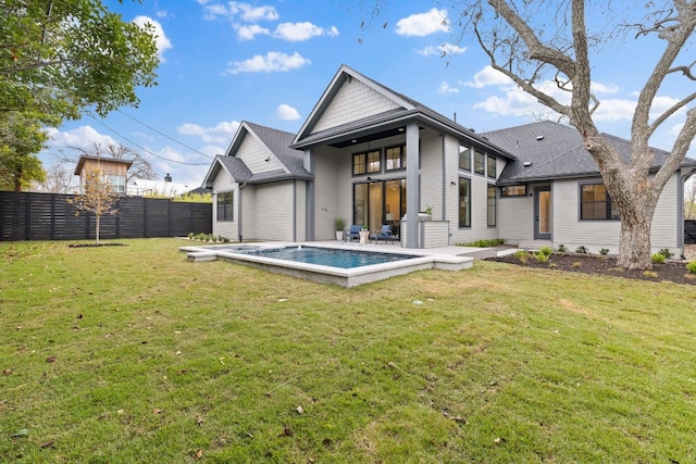 back of property featuring a fenced in pool and a yard