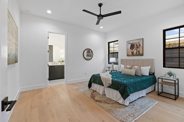 bedroom with ceiling fan, light hardwood / wood-style floors, sink, and ensuite bathroom