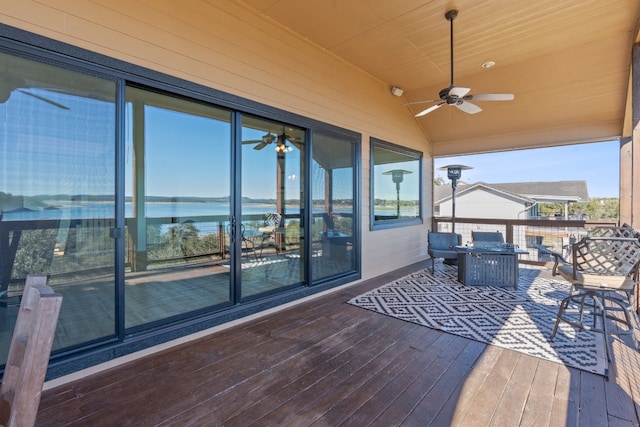 wooden terrace featuring ceiling fan and a water view