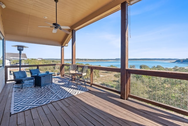 wooden terrace with an outdoor hangout area, a water view, and ceiling fan