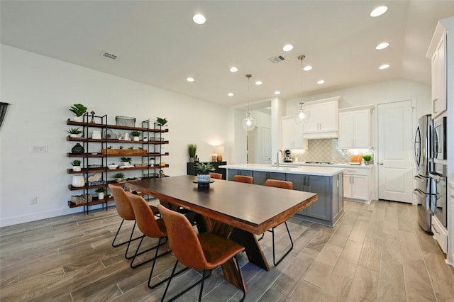 dining room featuring vaulted ceiling and sink