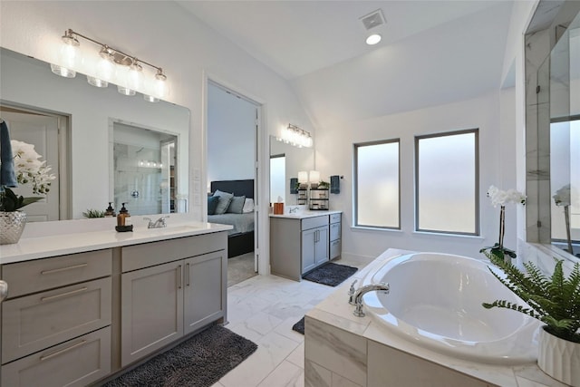 bathroom featuring vanity, independent shower and bath, and vaulted ceiling