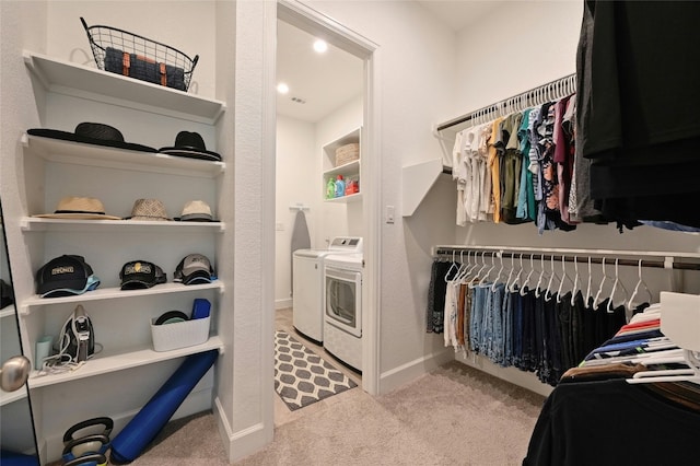 walk in closet featuring washer and dryer and light carpet