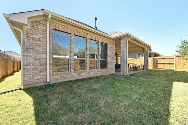 rear view of house with a lawn and a patio area