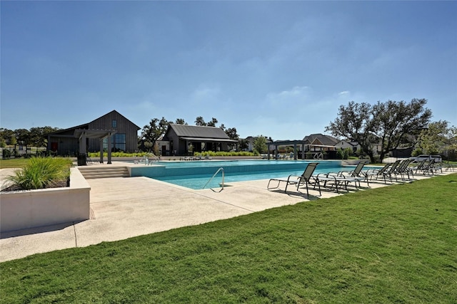 view of pool featuring a yard and a patio