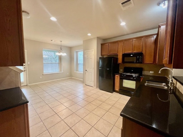 kitchen featuring sink, hanging light fixtures, an inviting chandelier, light tile patterned floors, and black appliances