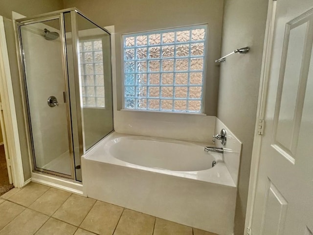 bathroom featuring tile patterned flooring and separate shower and tub