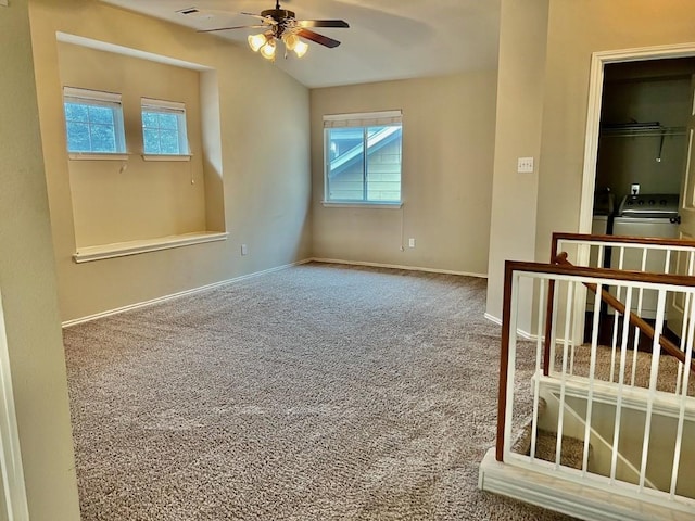 carpeted empty room with ceiling fan and washer / clothes dryer