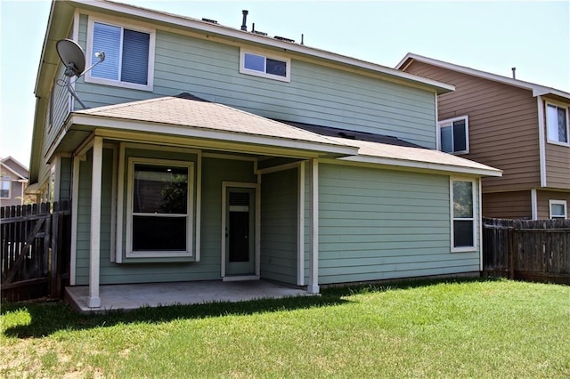 back of house featuring a lawn and a patio