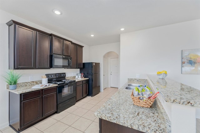 kitchen featuring sink, light tile patterned floors, dark brown cabinetry, and black appliances